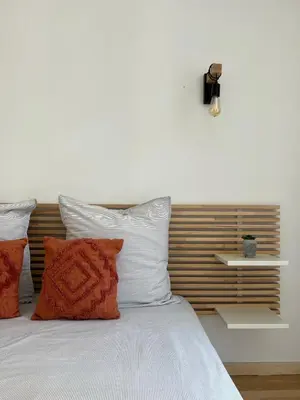 a bed with white sheets and orange pillows at Gorgeous town house in Narbonne