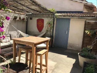 a wooden table and chairs on a patio at Appartement climatisé avec terrasse in Carcassonne