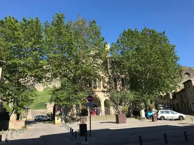 a building with a car parked in a parking lot at Appartement climatisé avec terrasse in Carcassonne
