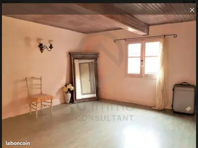 a living room with a chair and a mirror at Jolie maison de village à Roquecourbe in Roquecourbe