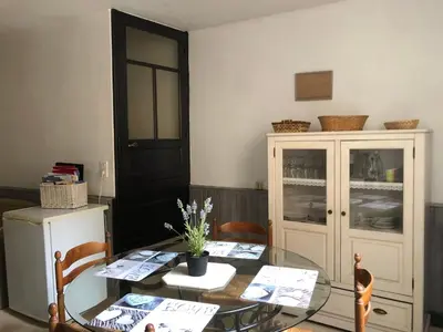 a dining room with a glass table and a cabinet at Jolie maison de village à Roquecourbe in Roquecourbe