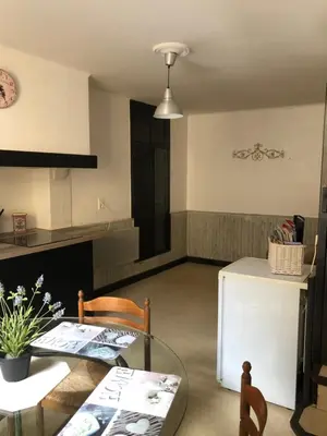 a living room with a table and a refrigerator at Jolie maison de village à Roquecourbe in Roquecourbe
