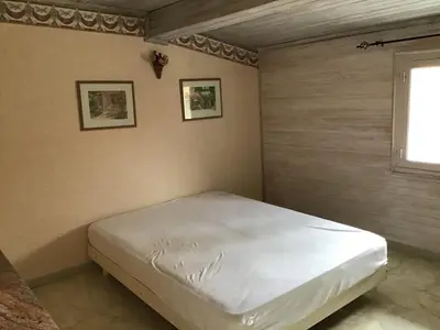 a bedroom with a white bed in a room with a window at Jolie maison de village à Roquecourbe in Roquecourbe