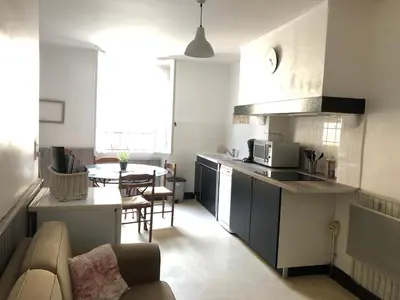 a kitchen and living room with a couch and a table at Jolie maison de village à Roquecourbe in Roquecourbe