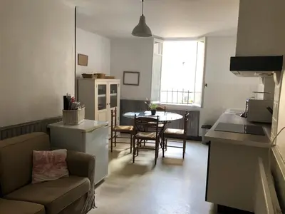 a kitchen and living room with a couch and a table at Jolie maison de village à Roquecourbe in Roquecourbe