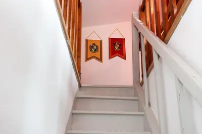 a staircase in a building with flags on the wall at HARRY POTTER - Escape Game - Expérience Magique in Carcassonne