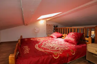 a bedroom with a large bed with red pillows at HARRY POTTER - Escape Game - Expérience Magique in Carcassonne