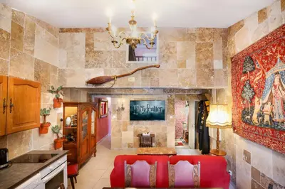 a kitchen with a red couch in a room at HARRY POTTER - Escape Game - Expérience Magique in Carcassonne