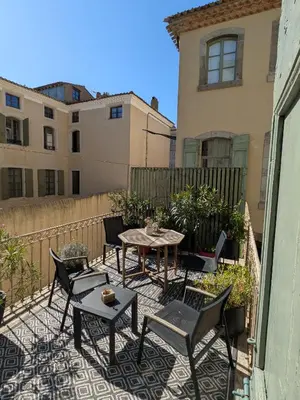 a patio with a table and chairs on a balcony at Maison ÉGLANTINE Historic 4 star with Air Conditioning in Carcassonne