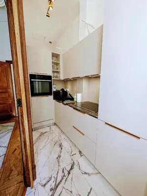 a kitchen with white cabinets and marble counter tops at Maison ÉGLANTINE Historic 4 star with Air Conditioning in Carcassonne