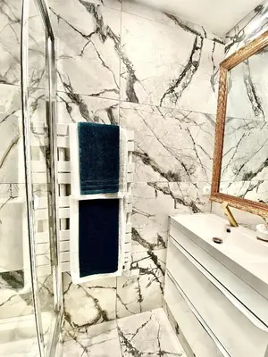 a marble bathroom with a shower and a sink at Maison ÉGLANTINE Historic 4 star with Air Conditioning in Carcassonne