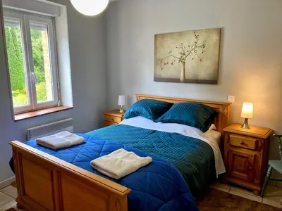 a bedroom with a blue bed with two towels on it at 3 Star 3 bed Air Conditioned QUERTINEUX 100m to Historic 4 Cathar Châteaux Lastours access to a very Pretty Riverside Garden!! in Lastours