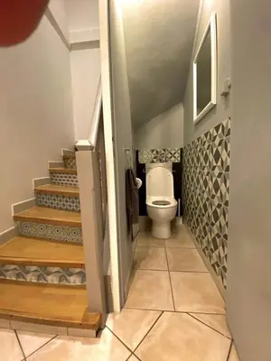 a bathroom with a toilet and stairs in it at 3 Star 3 bed Air Conditioned QUERTINEUX 100m to Historic 4 Cathar Châteaux Lastours access to a very Pretty Riverside Garden!! in Lastours