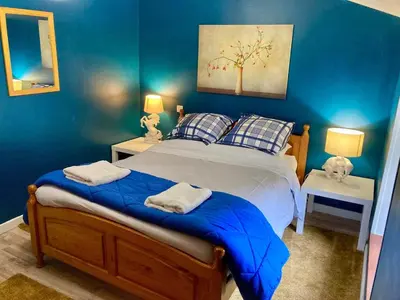 a blue bedroom with a large bed with blue walls at 3 Star 3 bed Air Conditioned QUERTINEUX 100m to Historic 4 Cathar Châteaux Lastours access to a very Pretty Riverside Garden!! in Lastours