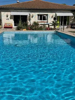 a large blue swimming pool in front of a house at Bel Hotel Restaurant la Gentilhommière in Trèbes