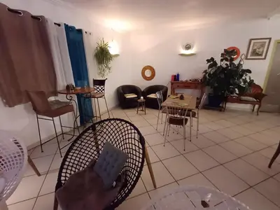 a living room with chairs and a table and tables at Bel Hotel Restaurant la Gentilhommière in Trèbes