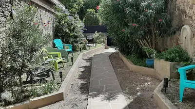 a garden with chairs and plants and a walkway at Le 9 de Cour, Chambre Caouette in Carcassonne