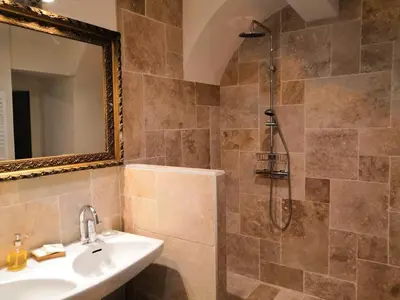 a bathroom with a sink and a shower with a mirror at Le 9 de Cour, Chambre Caouette in Carcassonne