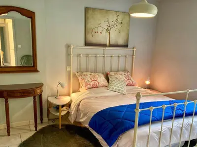a bedroom with a bed and a table and a mirror at Bijou SURDESPINE air conditioned 100m to Historic 4 Cathar Châteaux Lastours access to a very pretty riverside garden!! in Lastours