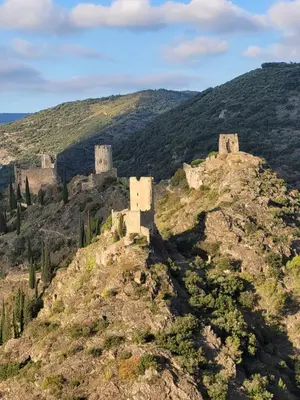 a castle on top of a mountain at Bijou SURDESPINE air conditioned 100m to Historic 4 Cathar Châteaux Lastours access to a very pretty riverside garden!! in Lastours