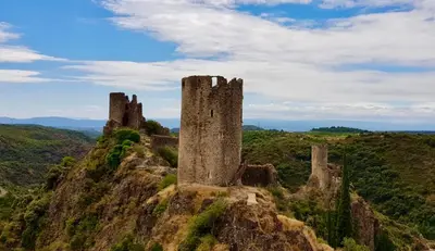 an old castle on top of a mountain at Bijou SURDESPINE air conditioned 100m to Historic 4 Cathar Châteaux Lastours access to a very pretty riverside garden!! in Lastours
