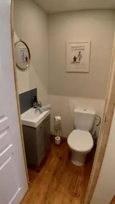 a bathroom with a white toilet and a sink at L'Oustal des amis in Belcaire