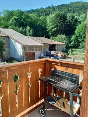 a grill on a deck with a view of a house at L'Oustal des amis in Belcaire