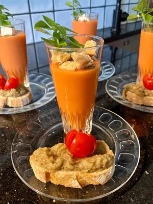 a glass of tomato juice on a plate with some bread at CheRiedel Bed & Breakfast & Art Gallery in Azillanet