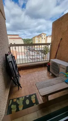 a balcony with a table and a bench on a balcony at Gruissan-Port-T3-2chambres-5pers-43m2-Parking-Clim-Piscine-Valerie in Gruissan