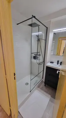 a glass shower in a bathroom with a sink at Gruissan-Port-T3-2chambres-5pers-43m2-Parking-Clim-Piscine-Valerie in Gruissan