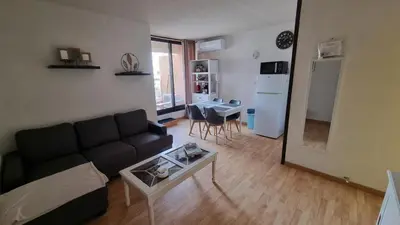 a living room with a couch and a table at Gruissan-Port-T3-2chambres-5pers-43m2-Parking-Clim-Piscine-Valerie in Gruissan