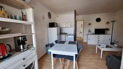 a kitchen and dining room with a table and chairs at Gruissan-Port-T3-2chambres-5pers-43m2-Parking-Clim-Piscine-Valerie in Gruissan
