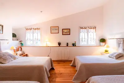 a bedroom with two beds and two windows at l'Oeil de Carcassonne in Caudebronde