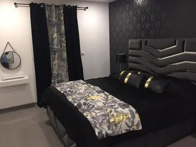 a bedroom with a bed with a black and white comforter at Villa privative 3 chambres et piscine priv près Carcassonne in Carcassonne