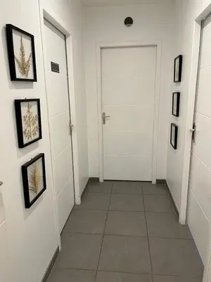 a hallway with a white door and pictures on the walls at Villa privative 3 chambres et piscine priv près Carcassonne in Carcassonne