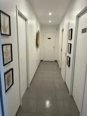 a hallway with white walls and a tile floor at Villa privative 3 chambres et piscine priv près Carcassonne in Carcassonne