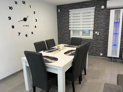 a dining room table with chairs and a clock on the wall at Villa privative 3 chambres et piscine priv près Carcassonne in Carcassonne
