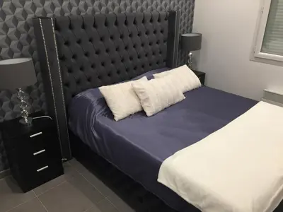 a bedroom with a bed with a black padded headboard at Villa privative 3 chambres et piscine priv près Carcassonne in Carcassonne