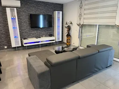 a living room with a couch and a tv at Villa privative 3 chambres et piscine priv près Carcassonne in Carcassonne