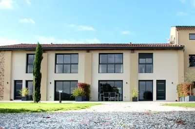 a house with black windows and a driveway at Domaine des Marronniers in Tourtrol