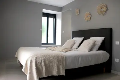 a bedroom with a large bed with white sheets and pillows at Domaine des Marronniers in Tourtrol