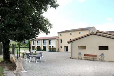 a group of chairs and a table in front of a building at Domaine des Marronniers in Tourtrol