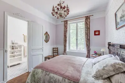 a bedroom with a large bed and a chandelier at Chateau de Pourpry in Damiatte