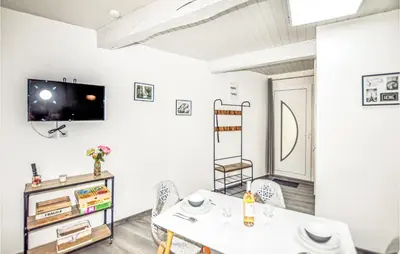 a living room with a table and chairs and a tv at 1 Bedroom Stunning Home In Bélesta in Bélesta
