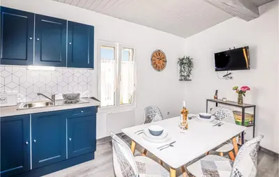 a kitchen with blue cabinets and a table with chairs at 1 Bedroom Stunning Home In Bélesta in Bélesta