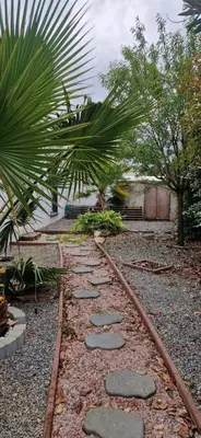 a walkway in a garden with a palm tree at Villa avec piscine sans vis-à-vis in Caux-et-Sauzens