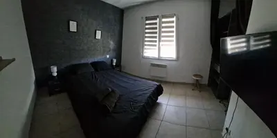 a bedroom with a black bed and a window at Villa avec piscine sans vis-à-vis in Caux-et-Sauzens