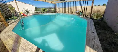 a large blue swimming pool with a wooden fence at Villa avec piscine sans vis-à-vis in Caux-et-Sauzens