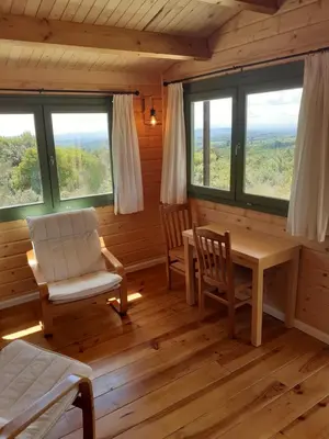 a room with a table and chairs and windows at Le Chalet in Saint-Jean-de-Minervois