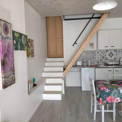 a staircase leading up to a kitchen with white walls at Alaric Lodge: gîte champêtre avec parking privé. in Comigne